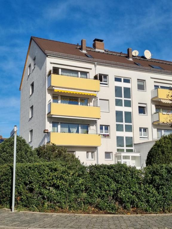 un grand bâtiment blanc avec des balcons jaunes dans l'établissement Raunheim, 2 Zimmer Dachgeschoss Apartment, à Raunheim