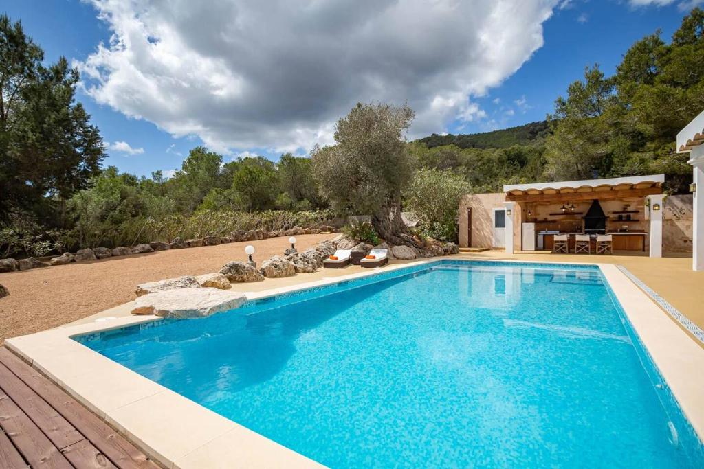 a swimming pool in a yard with a house at Amazing Finca With Pool & Forest - 4BR - Walk to UNVRS and AMNESIA in San Antonio