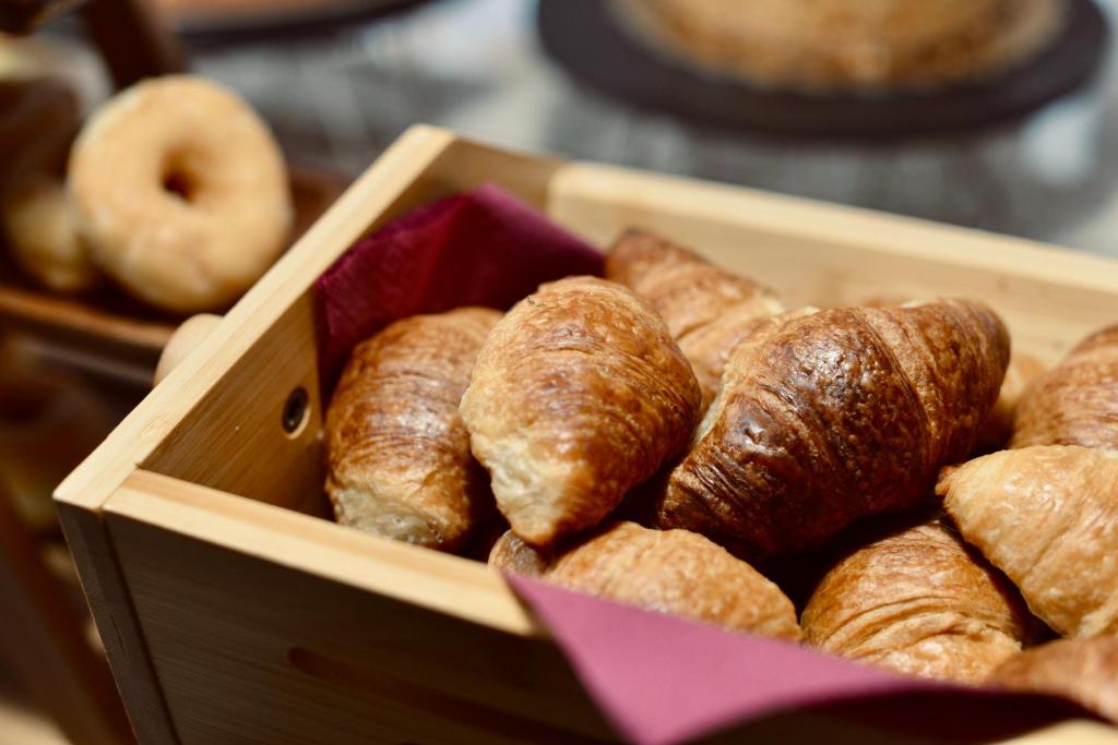 a wooden box filled with donuts and other pastries at Palermo Inn Boutique Arte in Palermo