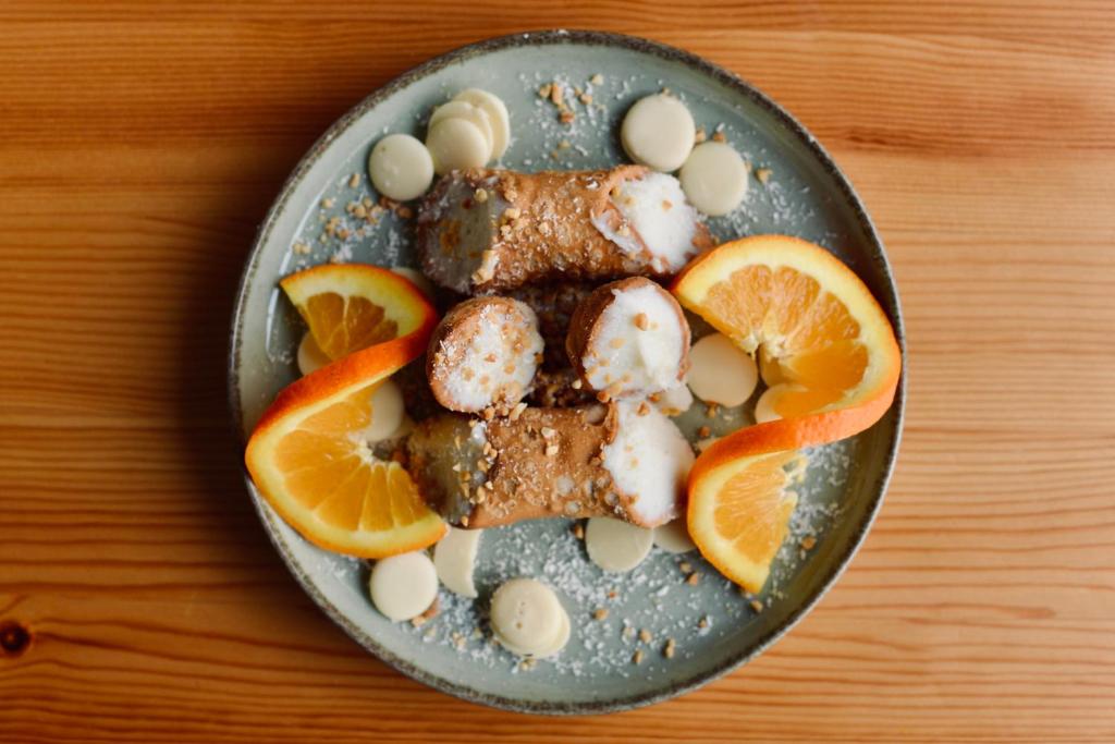 a plate of food with meat and orange slices at Palermo Inn Boutique Arte in Palermo