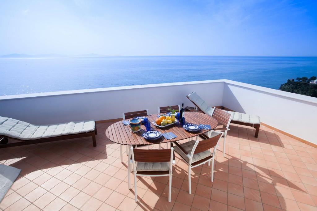 een tafel en stoelen op een balkon met uitzicht op de oceaan bij A casa di Laura in Amalfi