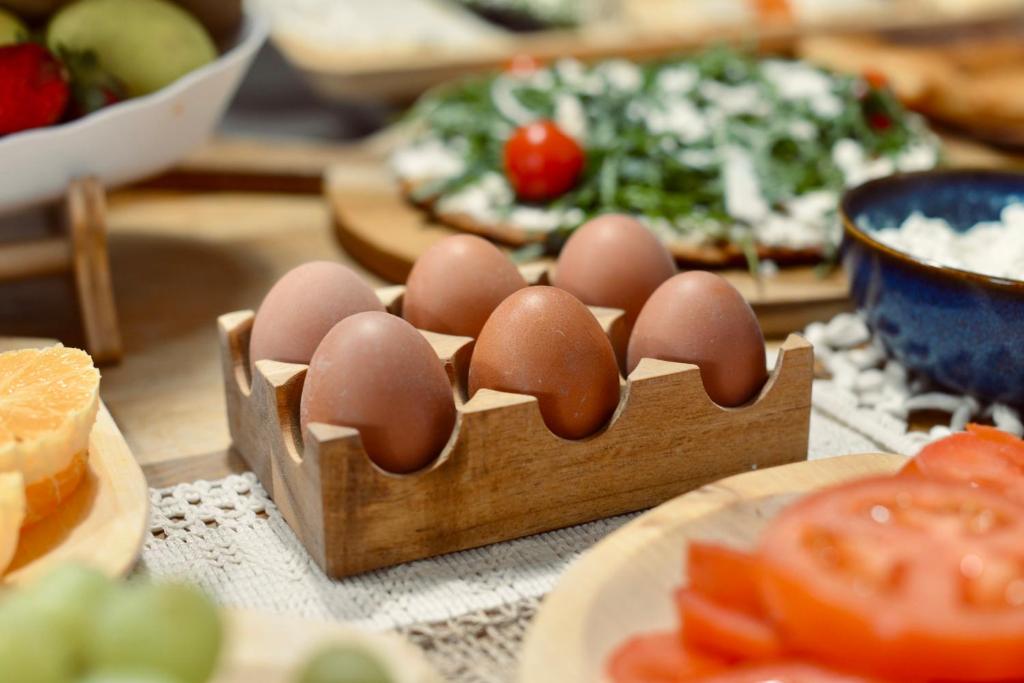 a table with eggs in a wooden box next to a pizza at Palermo Inn Boutique Arte in Palermo