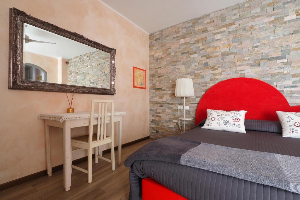 une chambre avec un lit rouge et une table avec un miroir dans l'établissement Dimora del Riccio, à Bergame