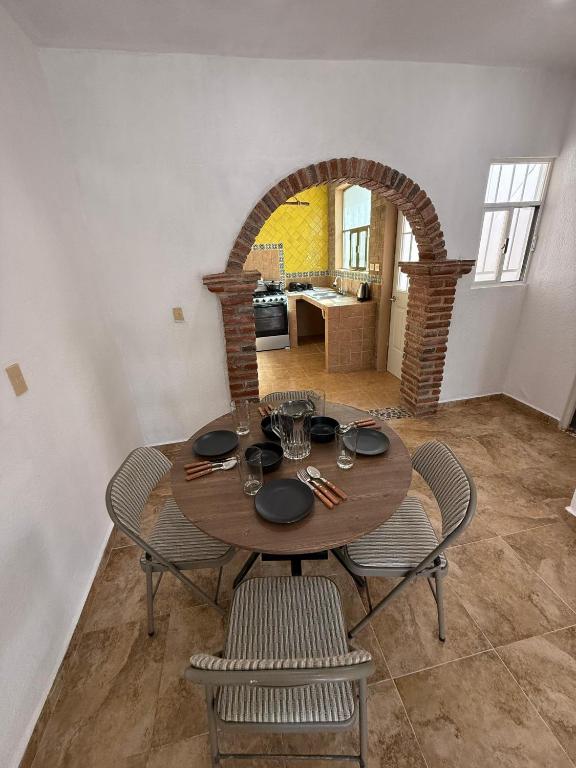 een eetkamer met een houten tafel en stoelen bij Casa Naay in Cancun