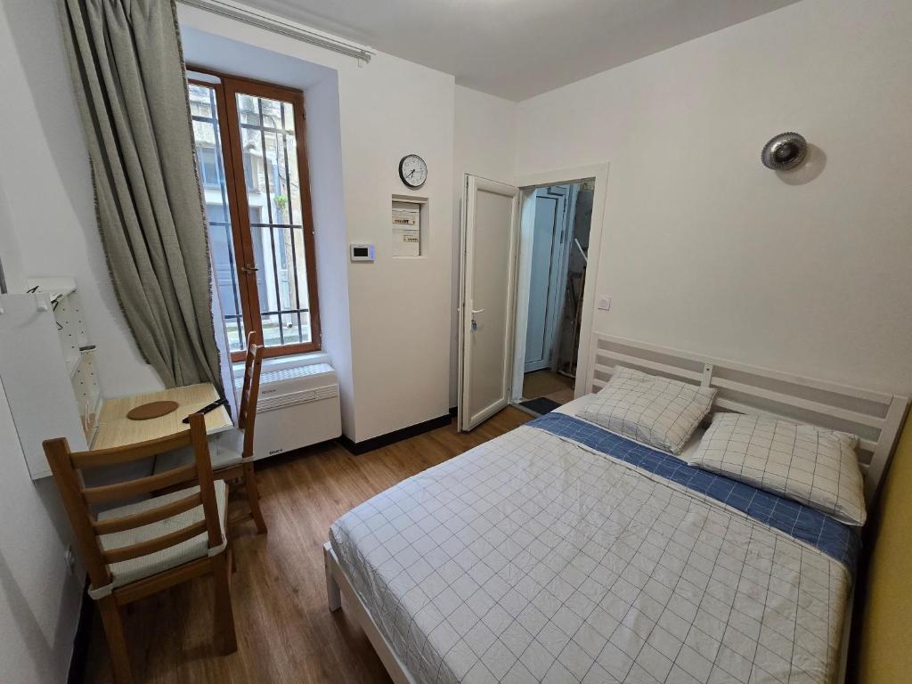 une chambre avec un lit, un bureau et une fenêtre dans l'établissement E0 - Beau studio en intramuros, rénové climatisé, à Avignon