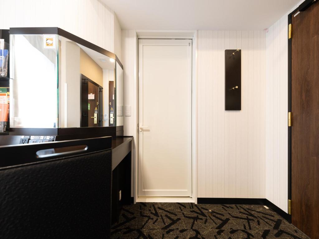 a bathroom with a white door and a mirror at APA Hotel Shibuya Dogenzakaue in Tokyo