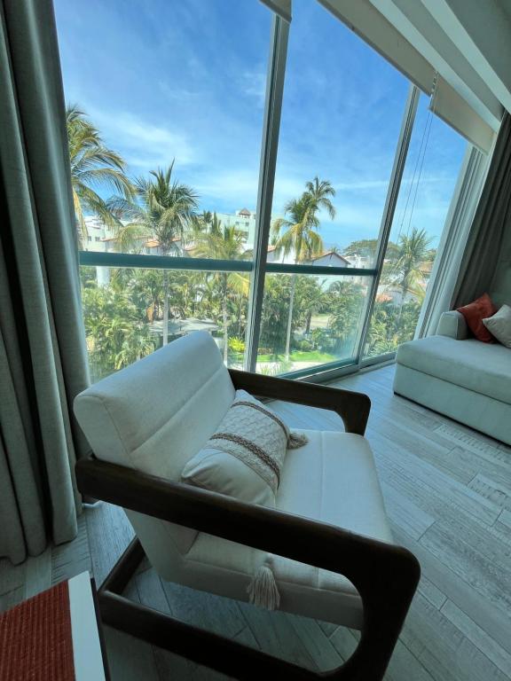 a living room with a white couch and a large window at TERRA 1B CONDO - Nuevo Nayarit in Nuevo Vallarta