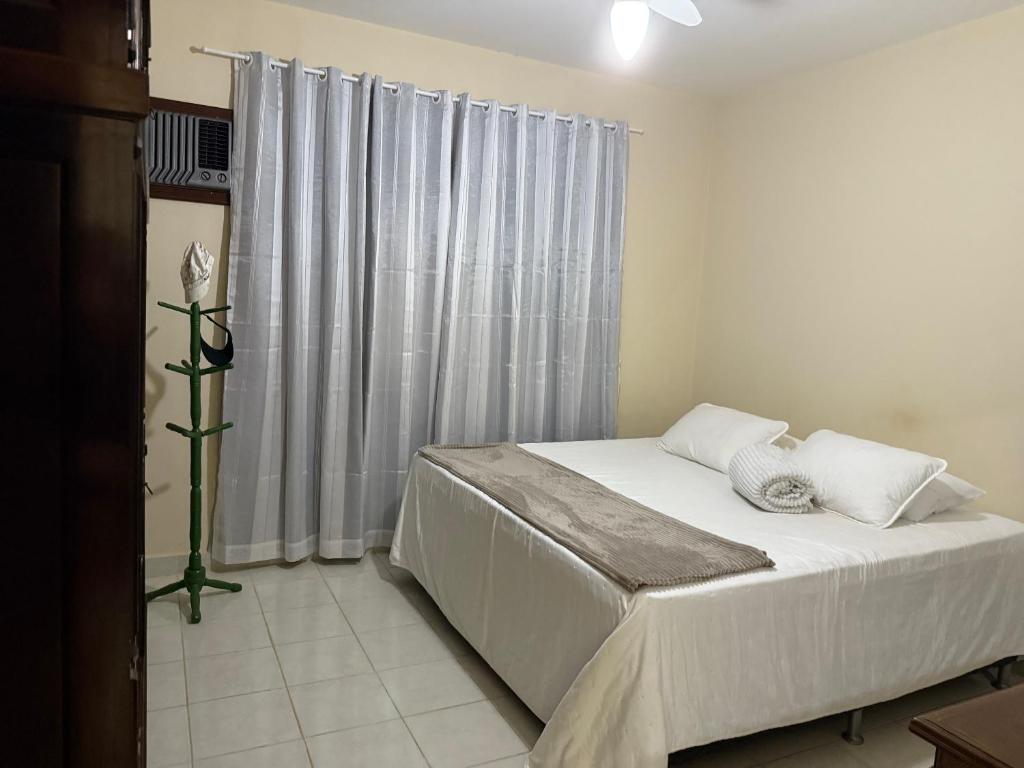 a bedroom with a white bed with a window at Rio quente Casa de Férias in Rio Quente
