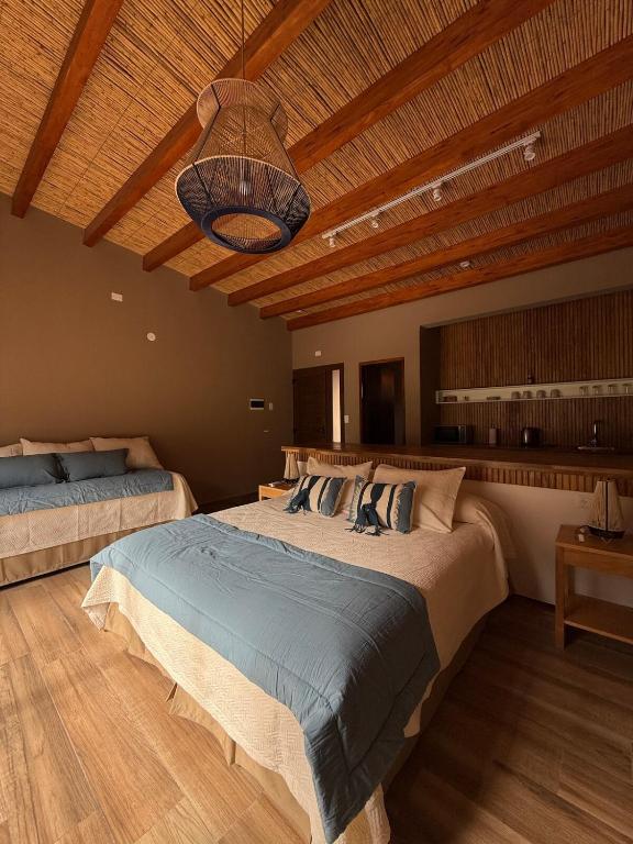 a bedroom with two beds and a wooden ceiling at Elegante Cabaña en Purmamarca in Purmamarca