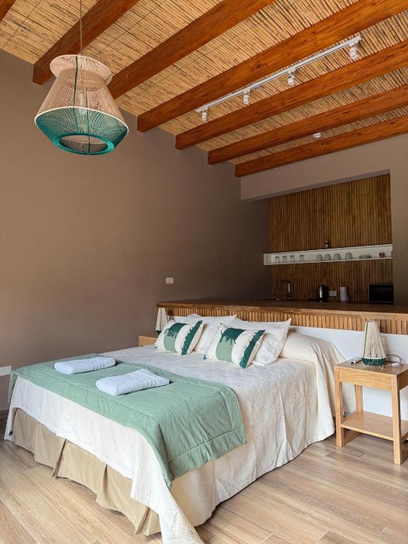 a bedroom with a large bed and a wooden ceiling at Encantadora Cabaña en Purmamarca in Purmamarca