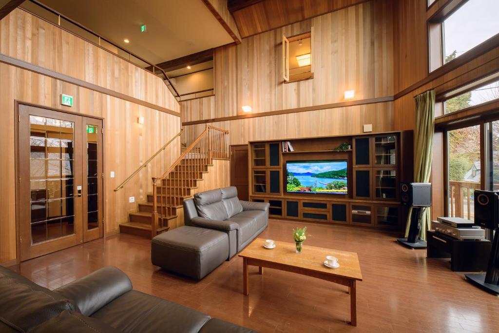 ein Wohnzimmer mit Sofa und Fernseher in der Unterkunft Hakone Ninotaira Cottage in Onsensō