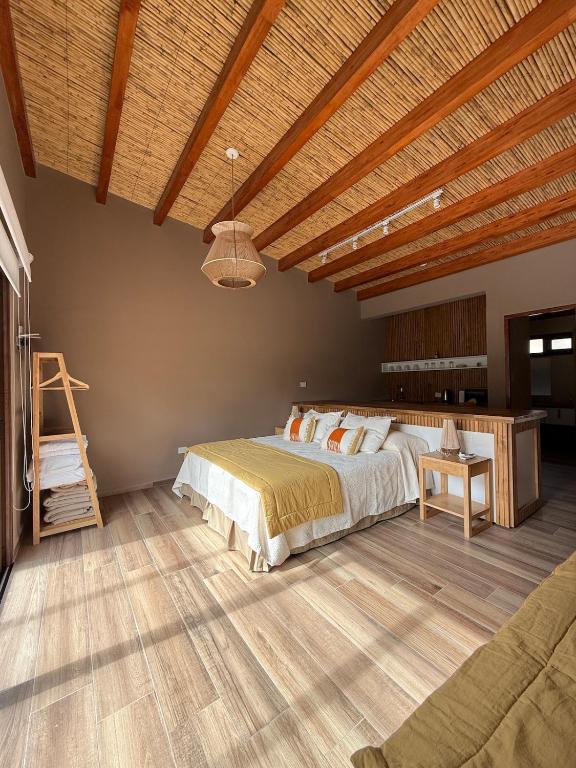 a bedroom with a large bed and a wooden ceiling at Distinguida Cabaña en Purmamarca in Purmamarca