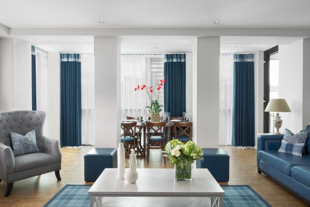 a living room filled with furniture and a large window at Princes Street Suites in Edinburgh