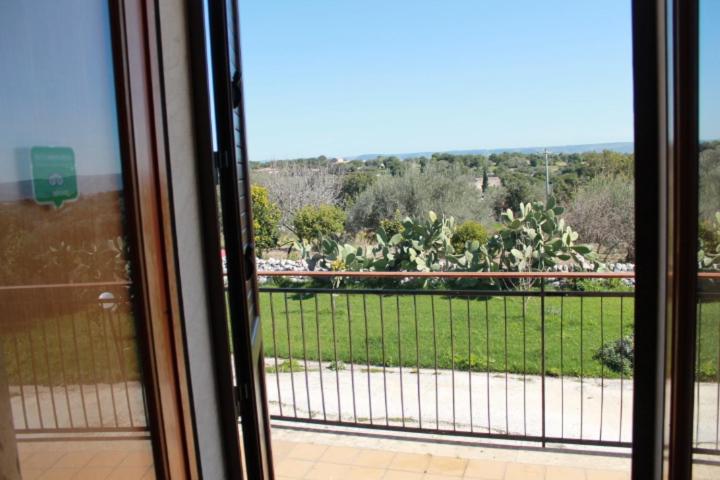 a sliding glass door with a view of a field at Le Due Palme - Il Paradiso di Adamo in Frigintini