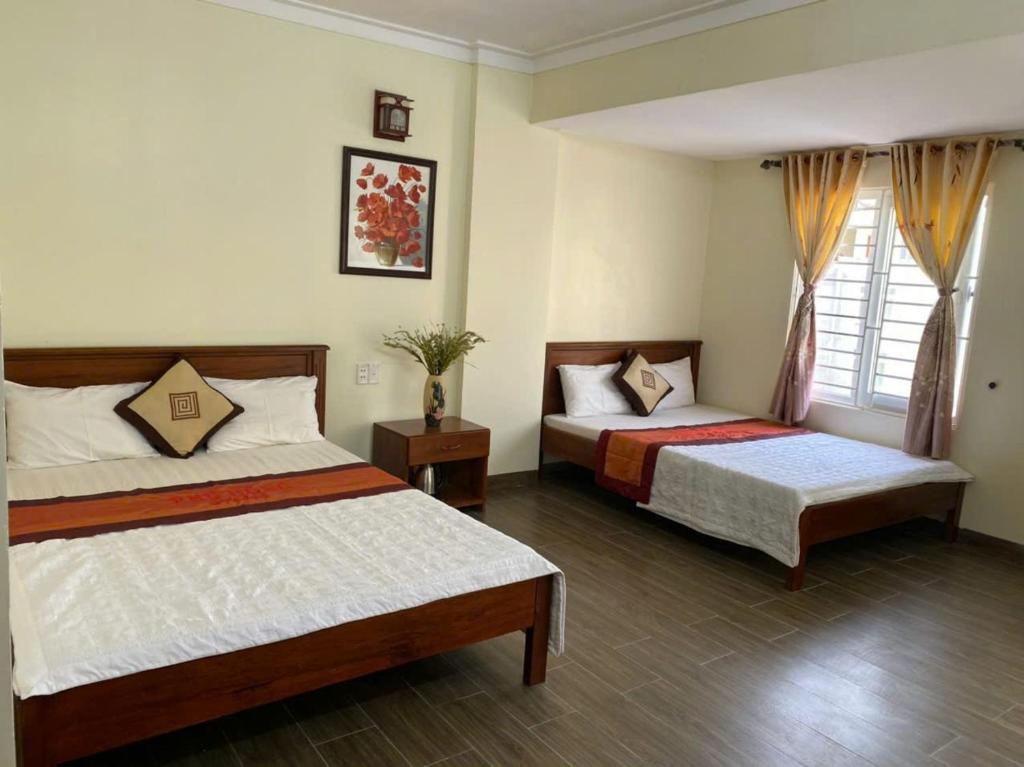 a bedroom with two beds and a window at Hoa Lư Hotel in Sầm Sơn