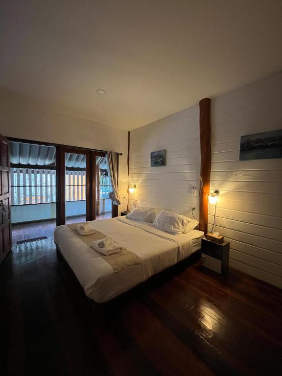 ein Schlafzimmer mit einem großen Bett und einem großen Fenster in der Unterkunft Ban Tha Ton Do Koh Yao noi in Ko Yao Noi