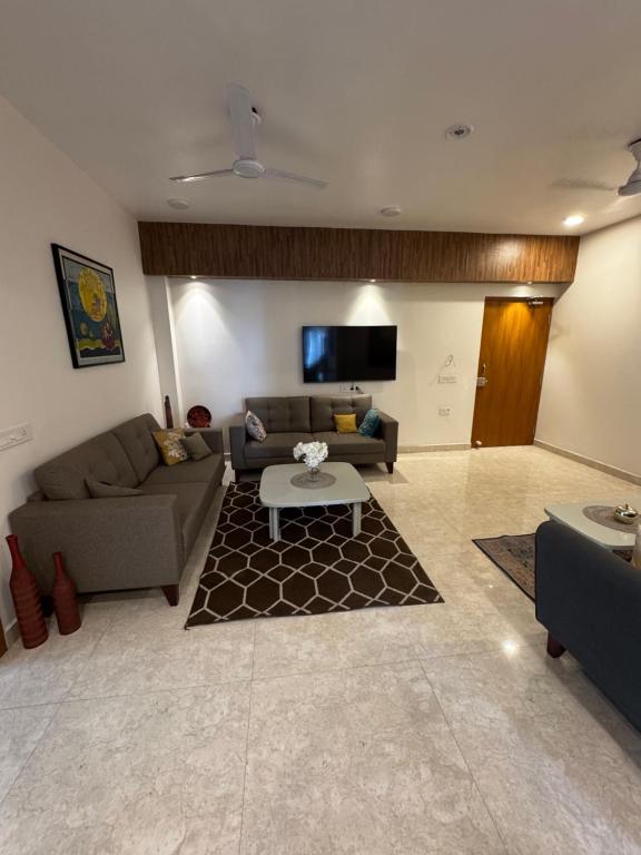 a living room with a couch and a table at Poonam apartments 2 in Prayagraj