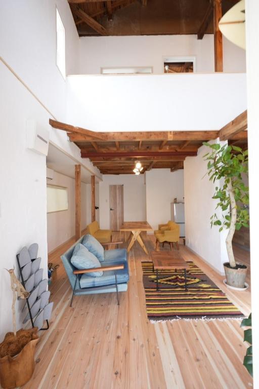 ein Wohnzimmer mit Holzboden und einem blauen Sofa in der Unterkunft Kumano Kodo Private House-CHILL HOUSE-Nachikatsuura in Nachikatsuura