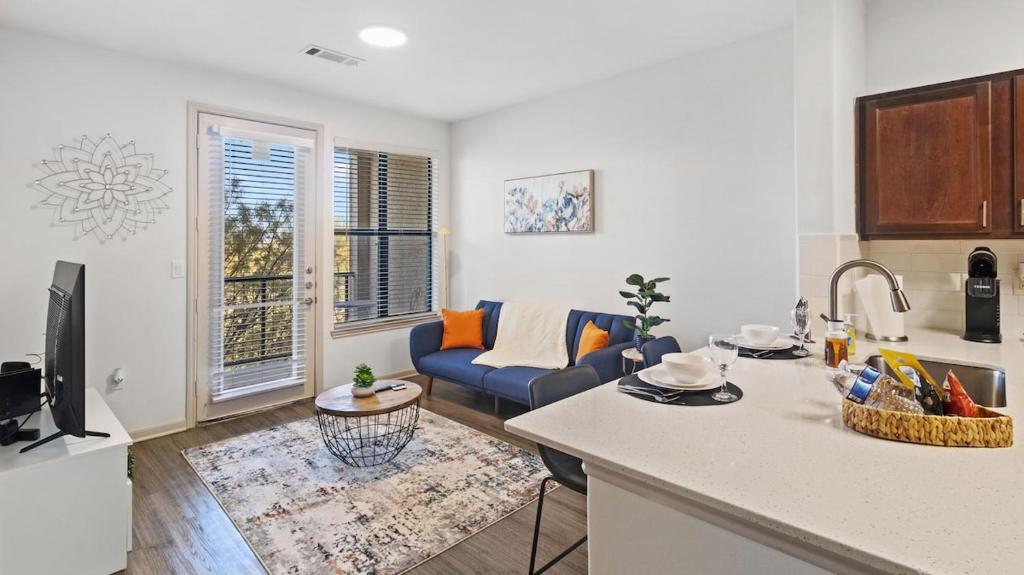 a kitchen and living room with a blue couch in a room at Stunning 1bd Apartment I Frisco near Dallas I Pool, Gym, Work Space in Frisco
