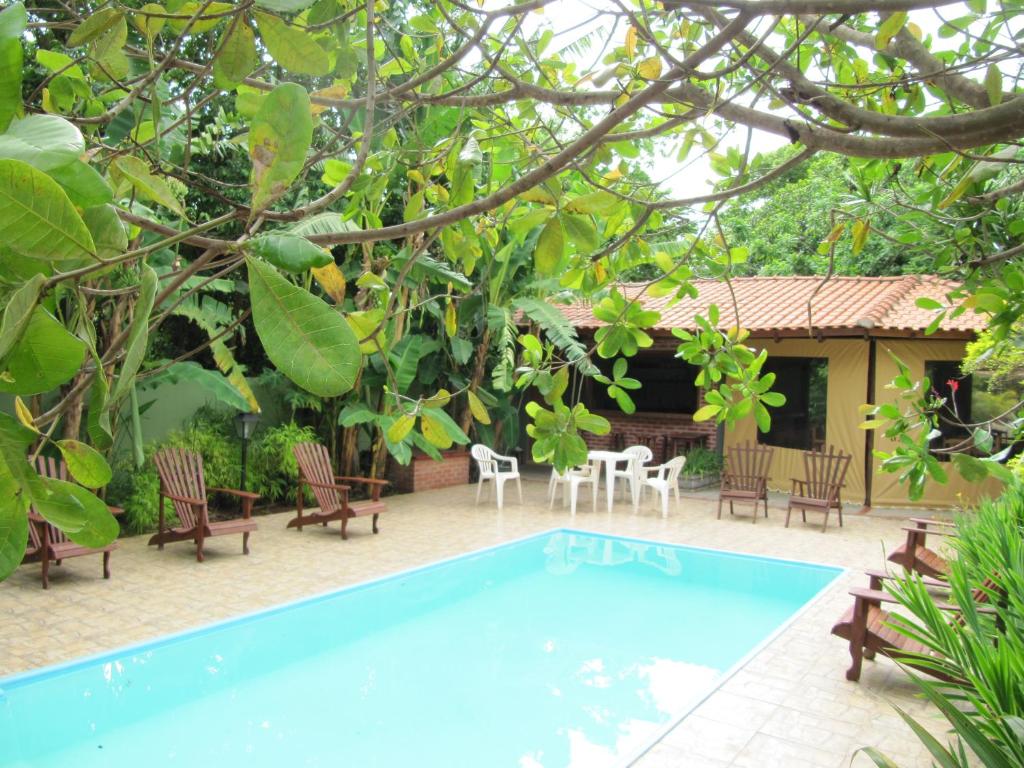 einen Pool in einem Garten mit Stühlen und einem Haus in der Unterkunft Eco Pousada Villa Verde in Bonito