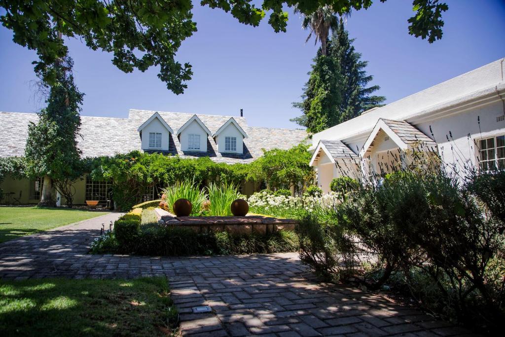 a house with a bench in front of a yard at Barney Barnato in Kimberley