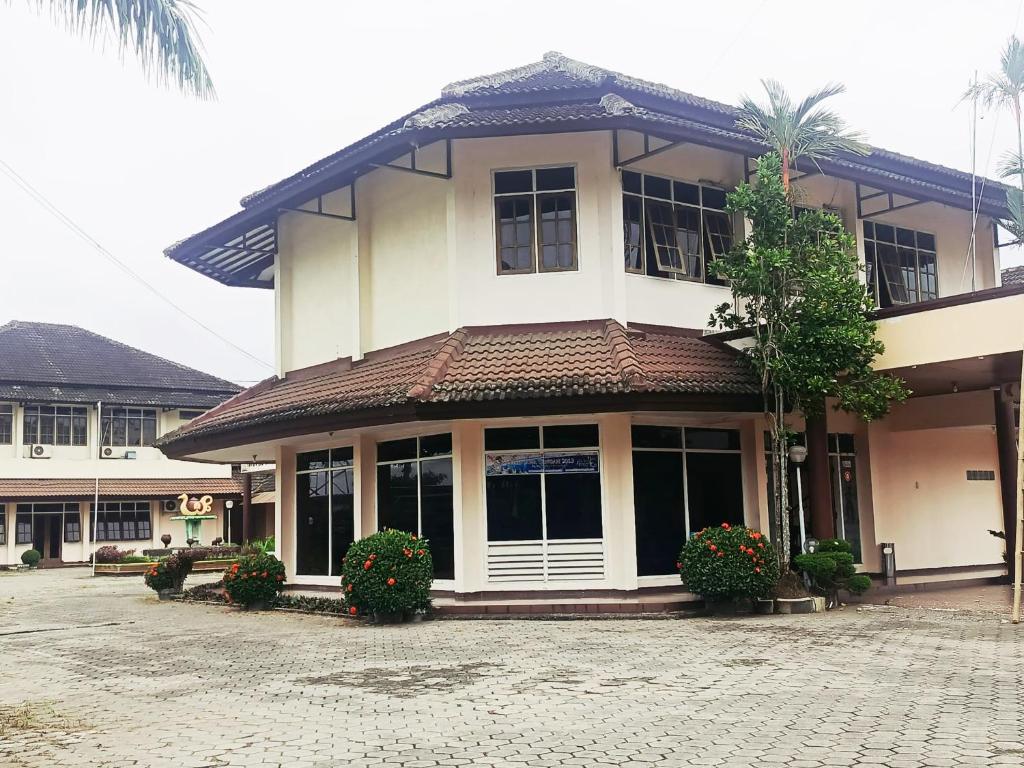 a large white building with windows and plants at Hotel Wijaya Purwokerto in Purwokerto