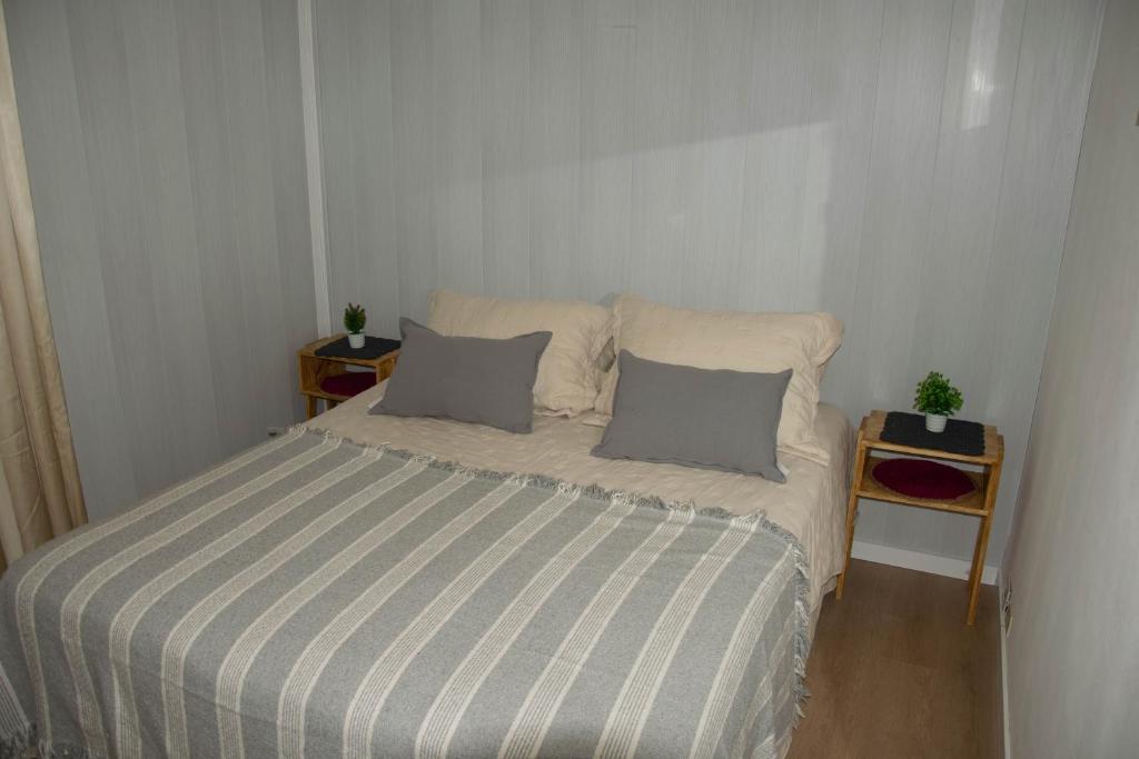 Schlafzimmer mit einem Bett mit gestreifter Decke in der Unterkunft Departamento 2 ambiente centrode buenos aires 2 cuadras del obelisco in Buenos Aires