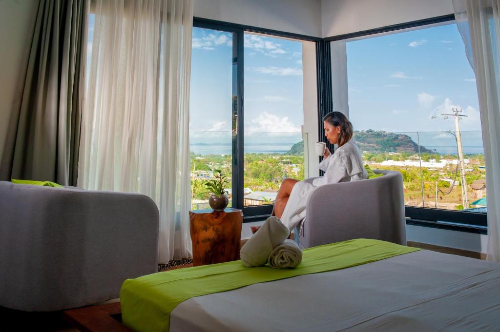 een vrouw in een stoel in een kamer met een raam bij Villa Vintana Nosy Be in Nosy Be