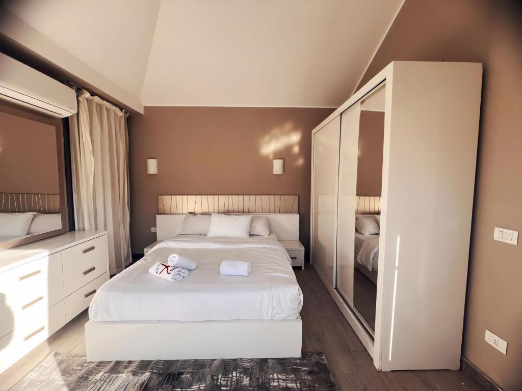 a bedroom with a white bed and a large mirror at Bali A 22 in Hurghada