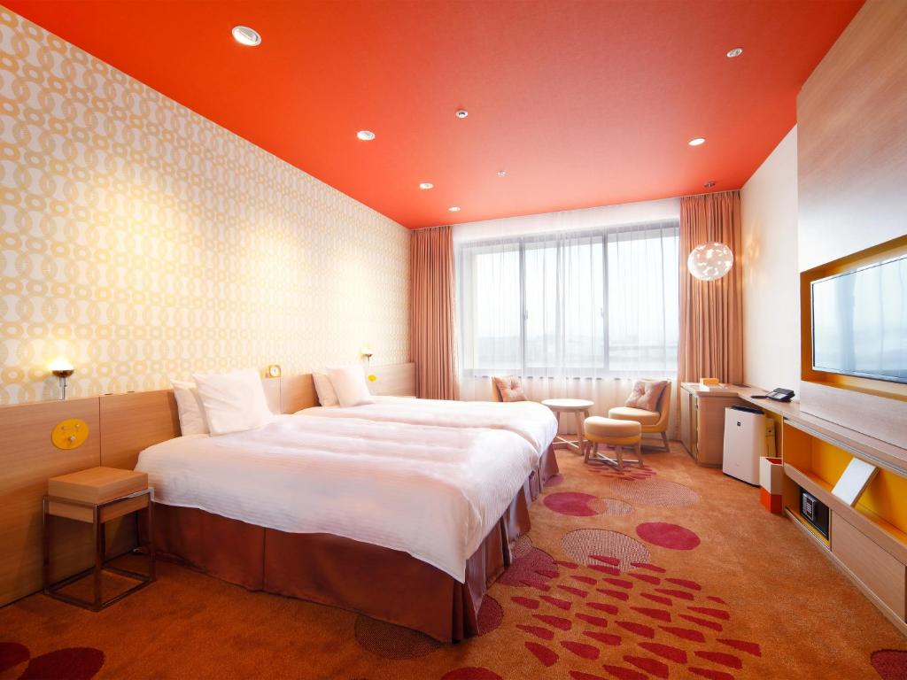 a hotel room with a large bed and a television at Hotel Universal Port Vita in Osaka