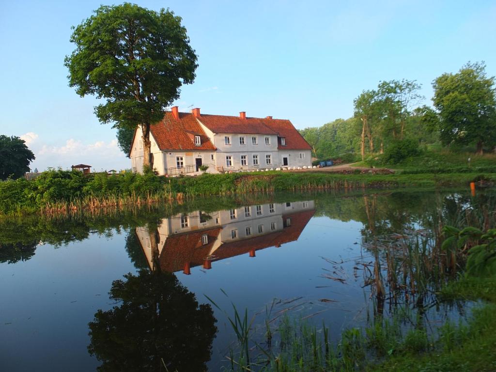a house sitting on the side of a river at Dwór Klewiny in Klewiny