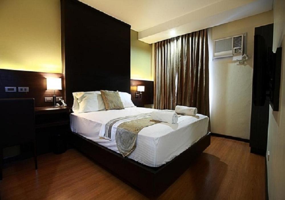Postel nebo postele na pokoji v ubytování Lorenzzo Suites Hotel Makati