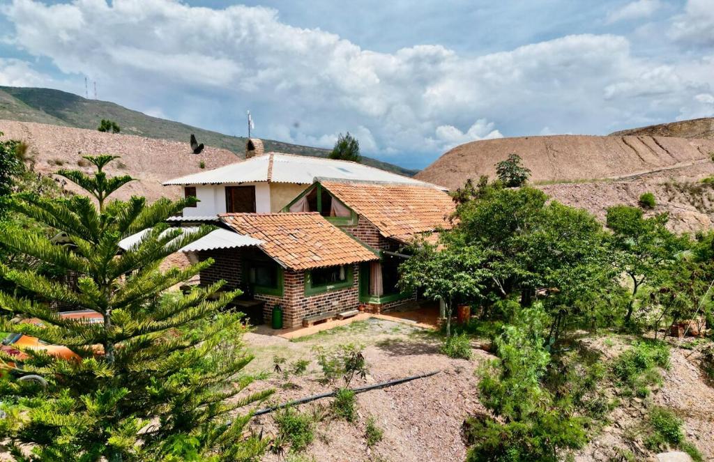 a house in the middle of a mountain at Xie-Hermosa cabaña con lago natural in Sáchica
