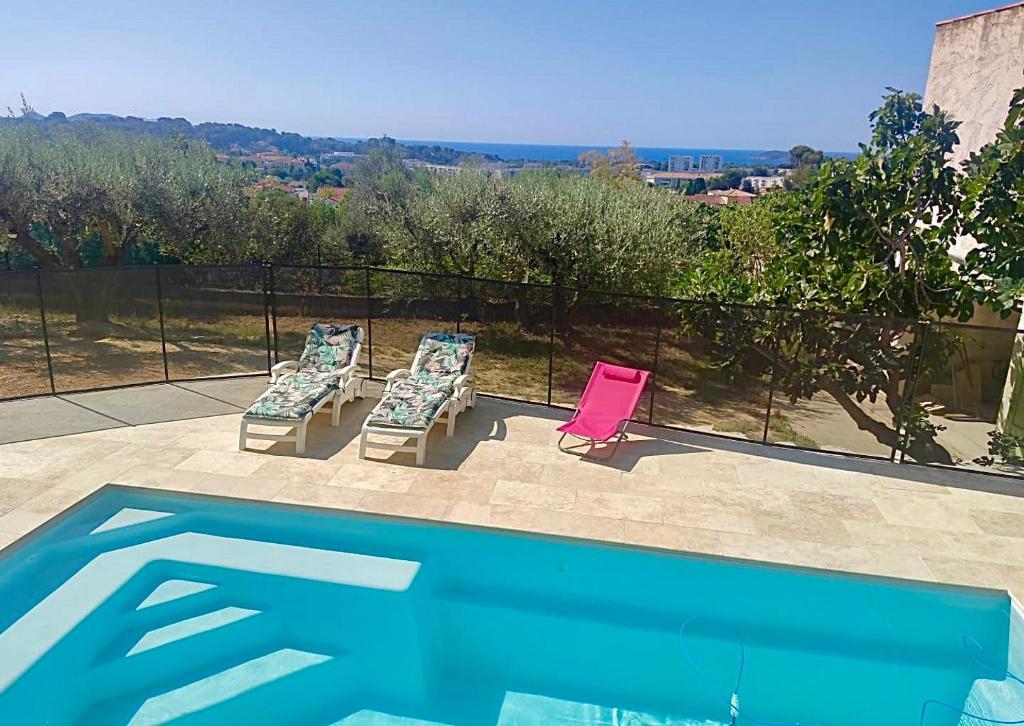 deux chaises assises à côté d'une piscine dans l'établissement Gite des Ecureuils, vue mer, piscine privée, parking, climatisation, à La Ciotat