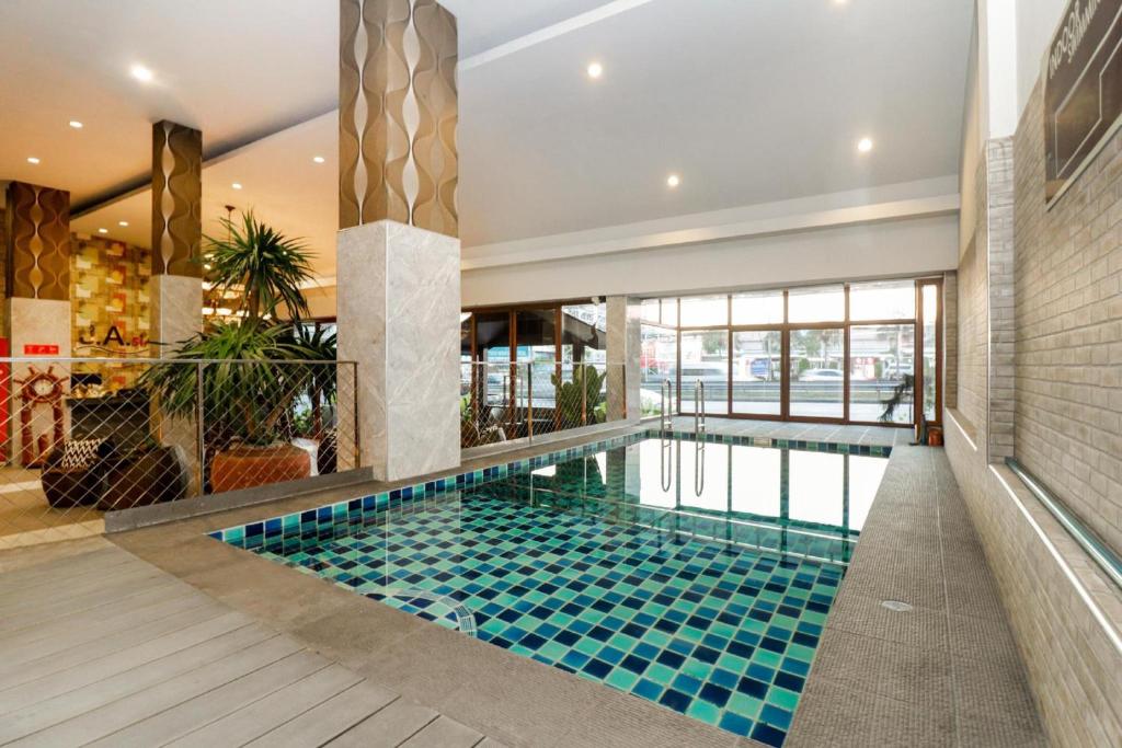 a swimming pool in the middle of a building at Collection O JA Siam City in Pattaya