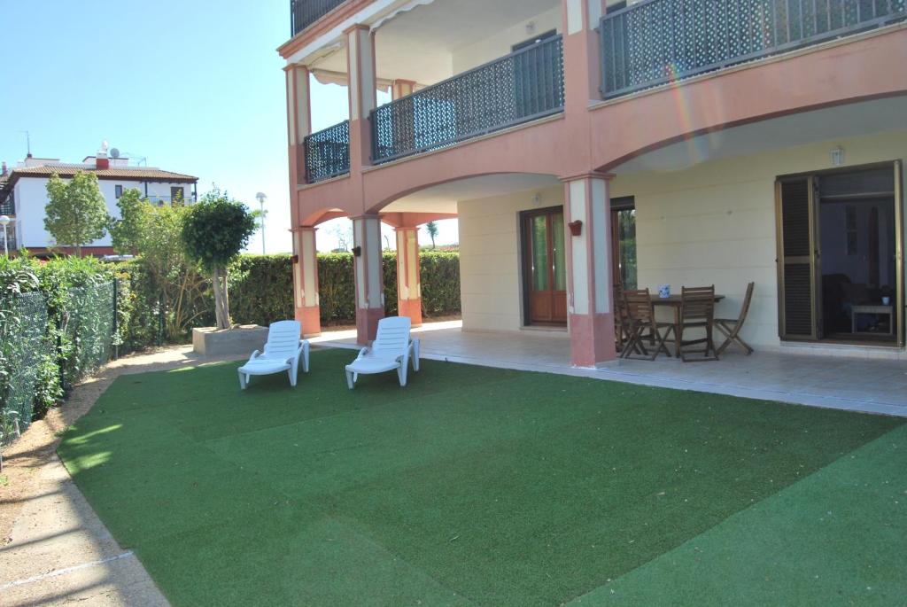 a patio with two chairs and a table on a lawn at Apartamento EL PARAÍSO in Ayamonte