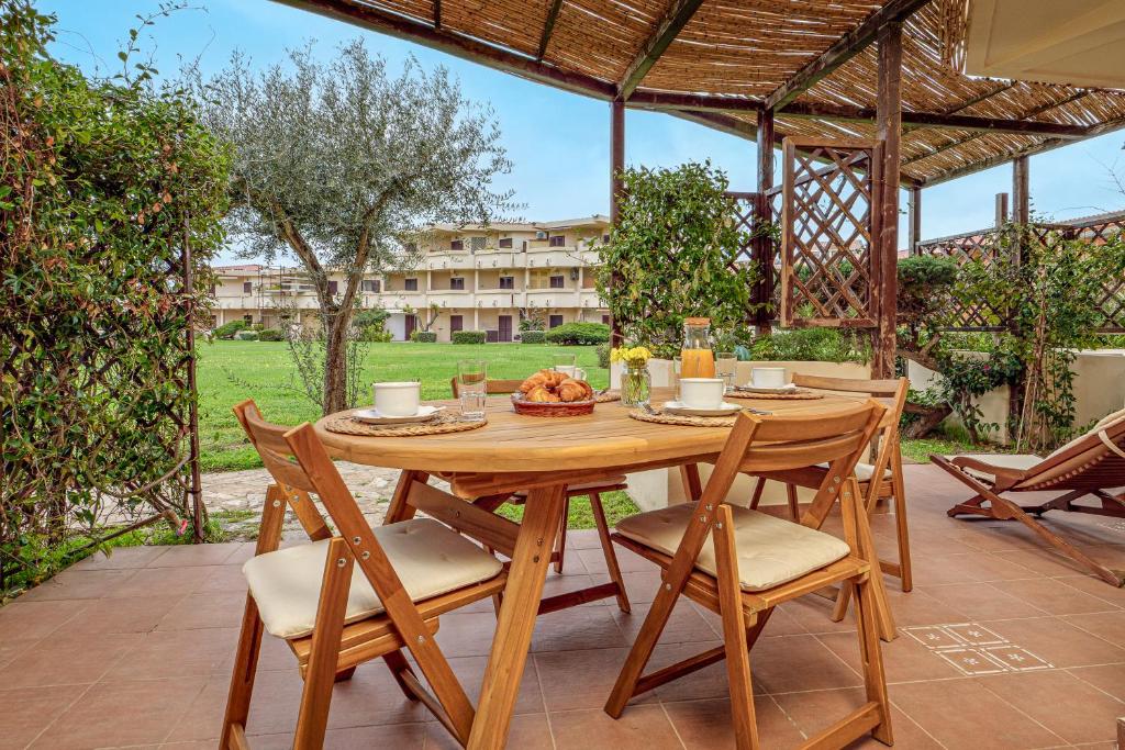 a wooden table and chairs on a patio at Casa Dina in Golfo Aranci