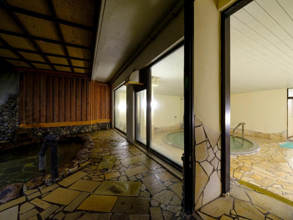 - une salle de bains avec 2 baignoires dans un bâtiment avec une fenêtre dans l'établissement Inasayama Kanko Hotel, à Nagasaki