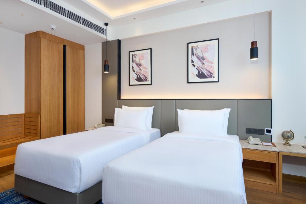 Postel nebo postele na pokoji v ubytování Iris Sarovar Portico