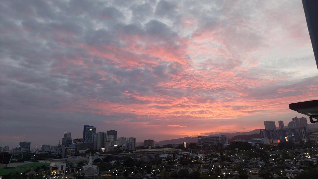 Un horizonte de ciudad con un cielo nublado al atardecer en aCed Staycation 6 pax accommodation, en Mandaue