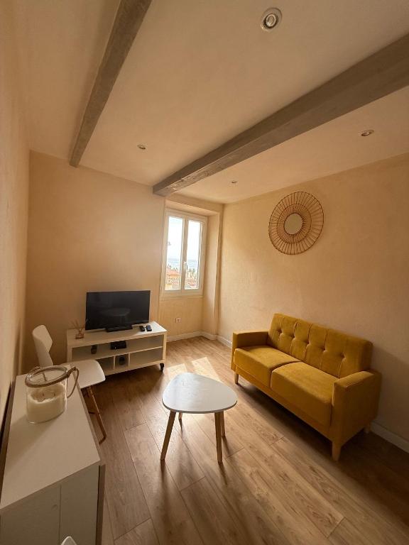 un salon avec un canapé jaune et une table dans l'établissement Séjour authentique avec vue mer à Menton, à Menton