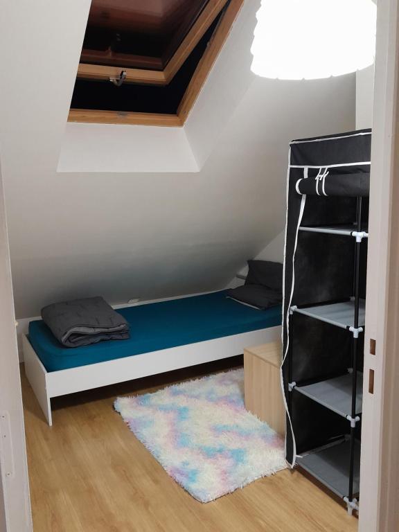 Cette petite chambre comprend un lit et une étagère. dans l'établissement Chambre Privée, à Mantes-la-Jolie