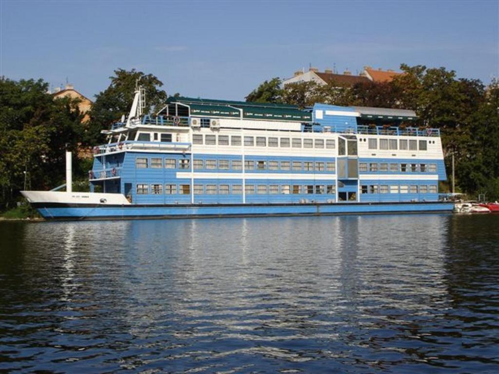 a large blue and white boat on the water at Botel Vodnik in Prague