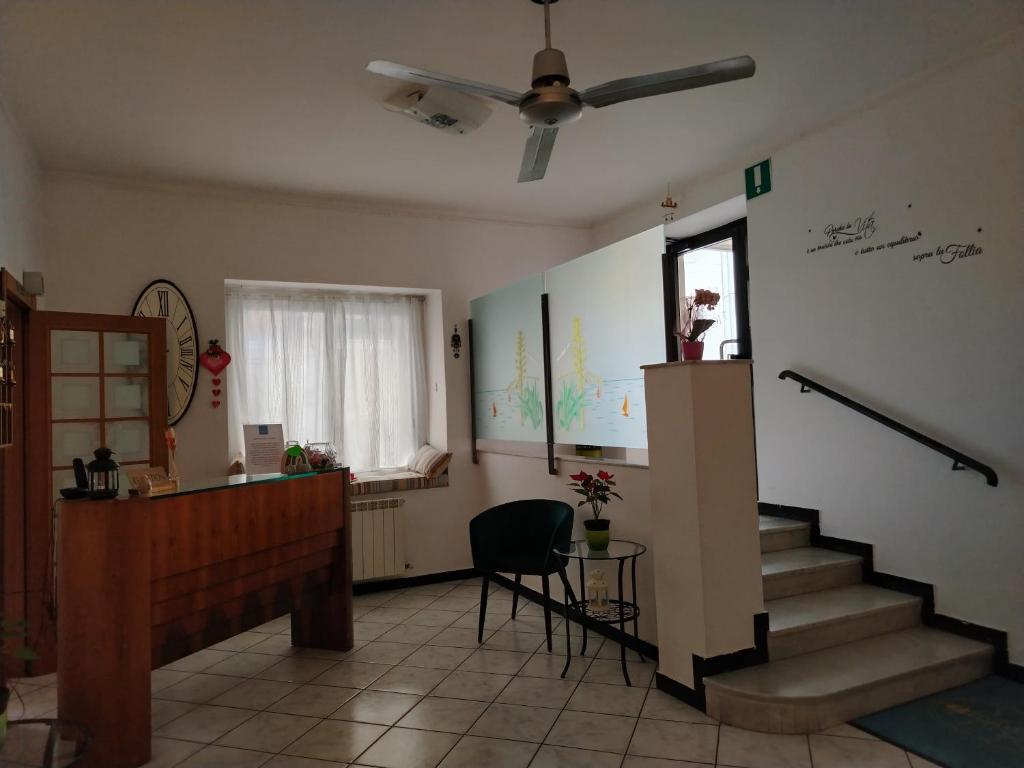 a living room with stairs and a ceiling fan at Hotel San Paolo in Varazze