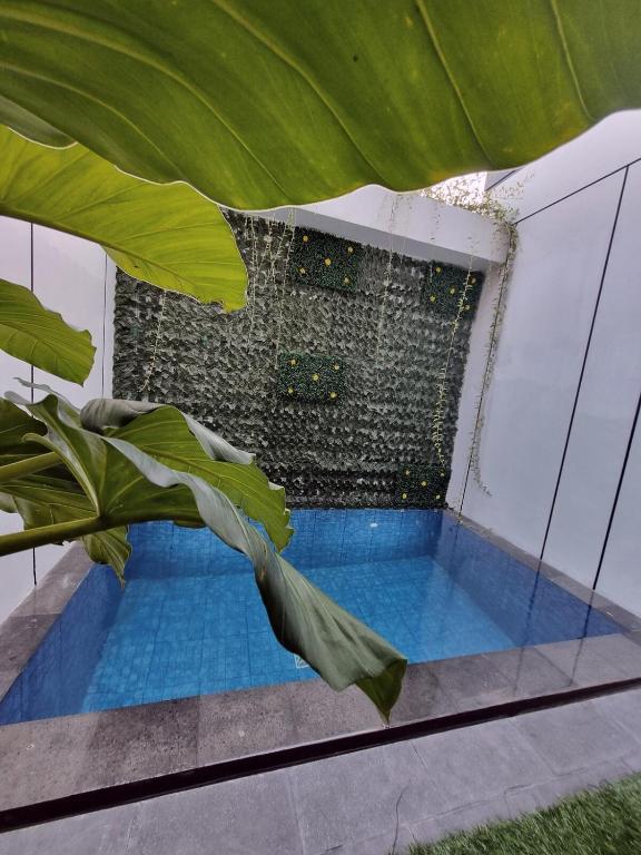 una piscina in una casa con una pianta di Villa Lotus Palagan Yogyakarta a Kejayan