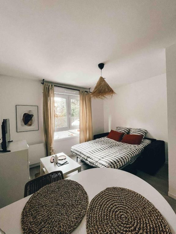 - un salon avec deux lits et une fenêtre dans l'établissement Studio cosy Ile de Nantes proche tram ligne 2 et 3, à Nantes