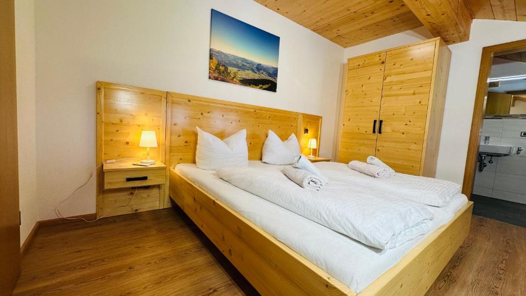 um quarto com uma cama grande com cabeceira de madeira em Ferienwohnung Beim Raffner em Ruhpolding