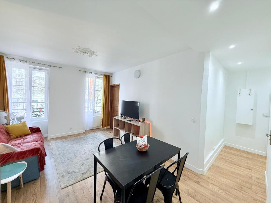 un salon avec une table et un canapé dans l'établissement Magnifique 2 pièces refait à neuf - Parking, à Paris