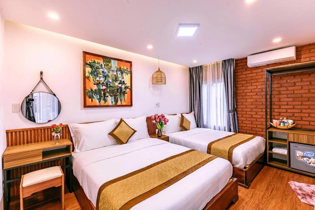 a hotel room with two beds and a television at Nana Homestay & Villa Apartment in Thôn Trường Giang