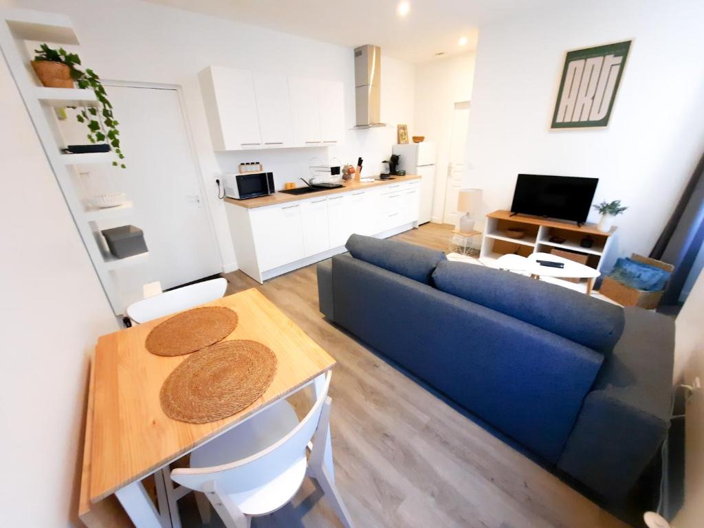 un salon avec un canapé bleu et une table dans l'établissement Le Foch - Apt 4 Personnes, 1 ch, Proche Gare, à Dijon